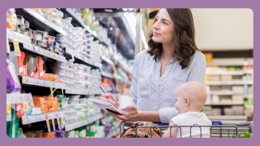 Postpartum mom reading nutrition labels at grocery store